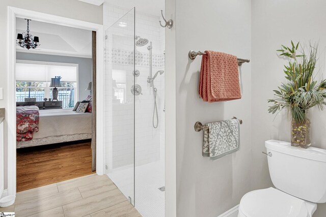 full bathroom with an inviting chandelier, toilet, a stall shower, and connected bathroom