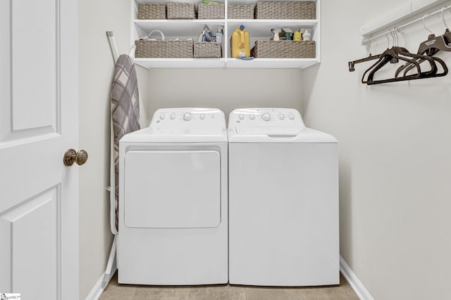 laundry area with washing machine and dryer, baseboards, and laundry area