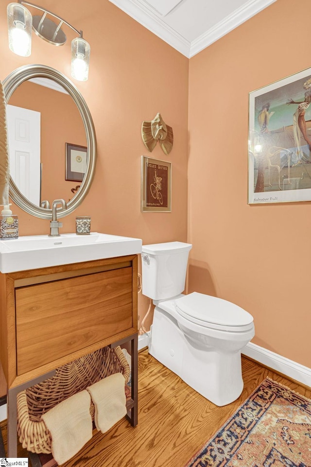 bathroom with crown molding, vanity, toilet, and baseboards