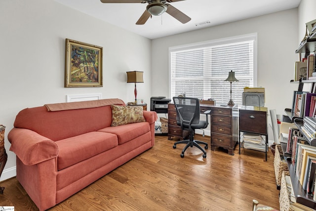 home office with ceiling fan, wood finished floors, and visible vents