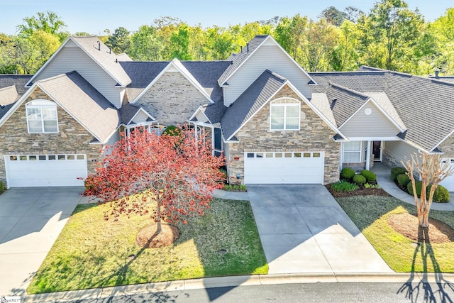 view of front of home with stone siding, driveway, and roof with shingles
