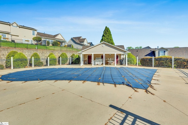 pool featuring a residential view, a patio area, and fence