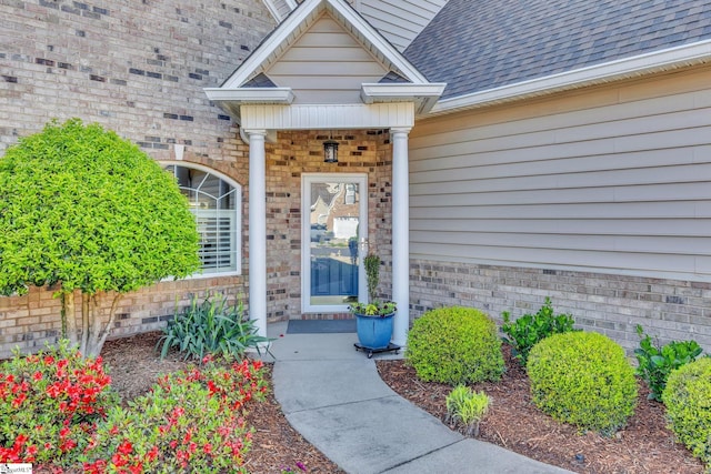 property entrance featuring a shingled roof