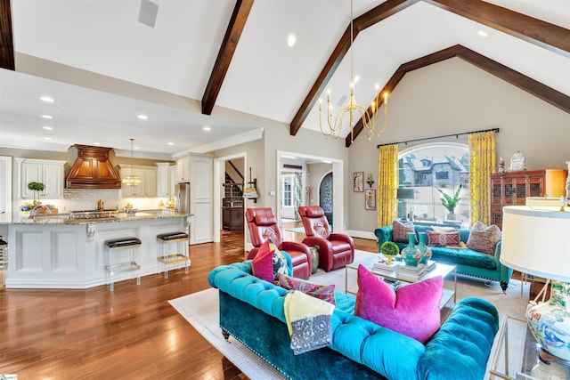 living room with wood finished floors, stairs, an inviting chandelier, beam ceiling, and recessed lighting