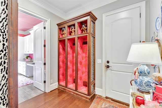 mudroom with crown molding, light wood finished floors, and baseboards