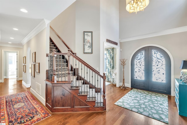 foyer entrance featuring wood-type flooring, stairway, plenty of natural light, and french doors