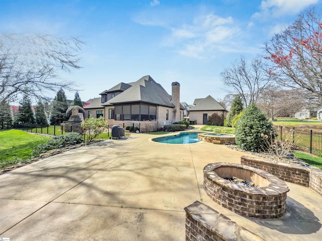 view of pool featuring fence, a patio area, an outdoor fire pit, and a pool with connected hot tub
