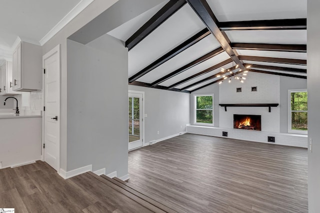 181 Skyland Dr, Clinton, SC 29325 - unfurnished living room with lofted ceiling with beams, dark wood-style floors, a sink, a notable chandelier, and a fireplace