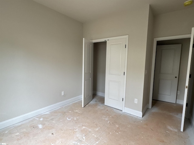 unfurnished bedroom featuring baseboards and a closet