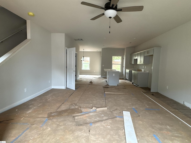 unfurnished living room featuring separate washer and dryer, baseboards, a ceiling fan, and visible vents