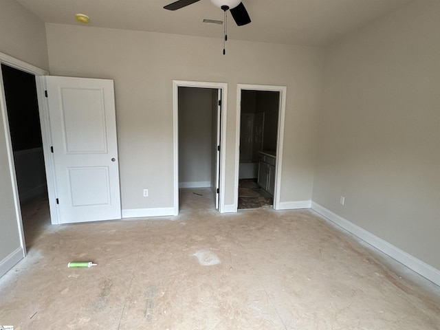 unfurnished bedroom with a walk in closet, a closet, baseboards, and ensuite bathroom