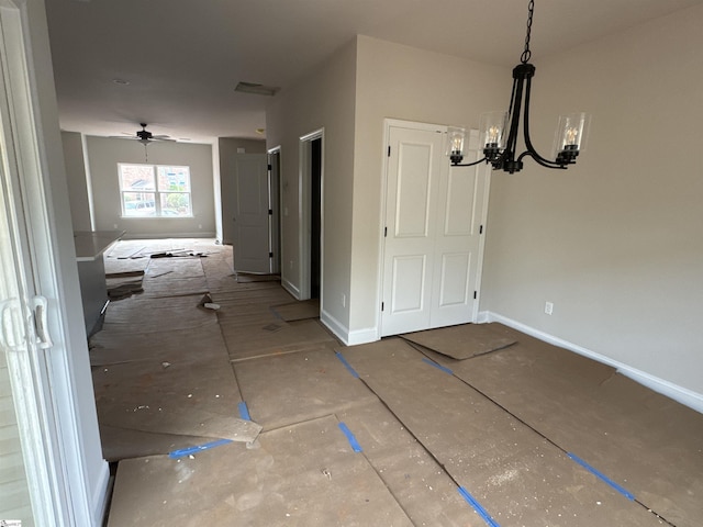 interior space featuring baseboards and an inviting chandelier