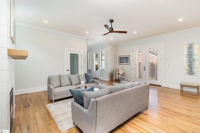 827 S Academy St, Greenville, SC 29601 - living room with french doors, light wood-type flooring, a ceiling fan, a fireplace, and ornamental molding