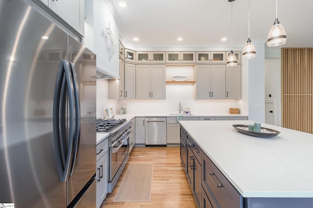 827 S Academy St, Greenville, SC 29601 - kitchen featuring stainless steel appliances, light wood-style floors, decorative light fixtures, a kitchen island, and tasteful backsplash