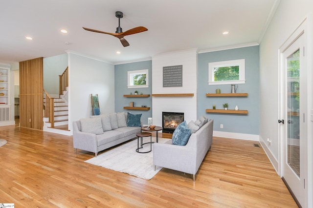 827 S Academy St, Greenville, SC 29601 - living area with stairway, a ceiling fan, ornamental molding, light wood-style floors, and a fireplace