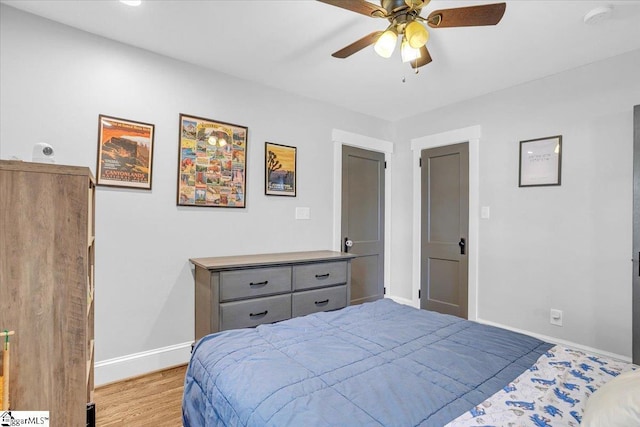 bedroom with ceiling fan, baseboards, and light wood-style floors