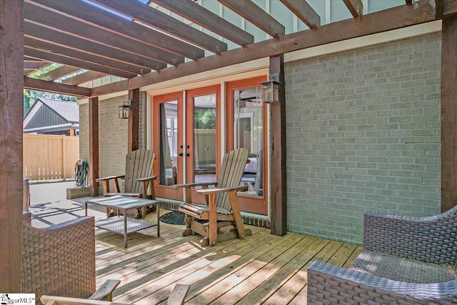 wooden terrace featuring a pergola, fence, and french doors