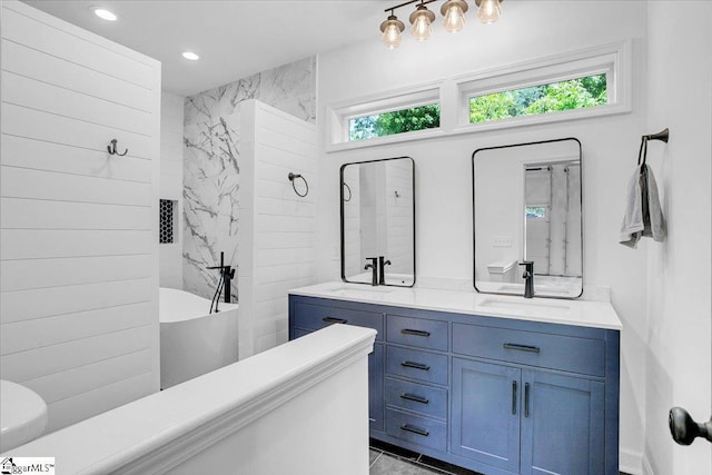 bathroom with a soaking tub, a sink, double vanity, and recessed lighting