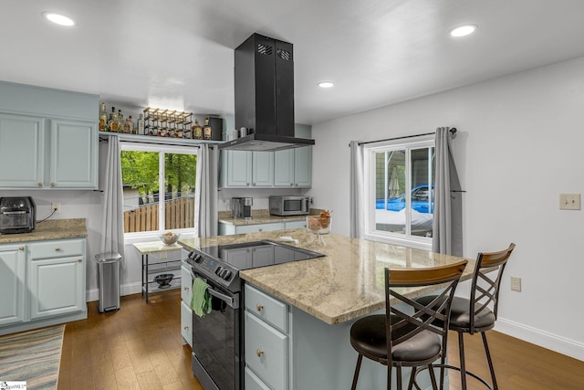 108A Holt Dr, Iva, SC 29655 - kitchen with island exhaust hood, dark wood-style floors, black range with electric stovetop, stainless steel microwave, and a center island