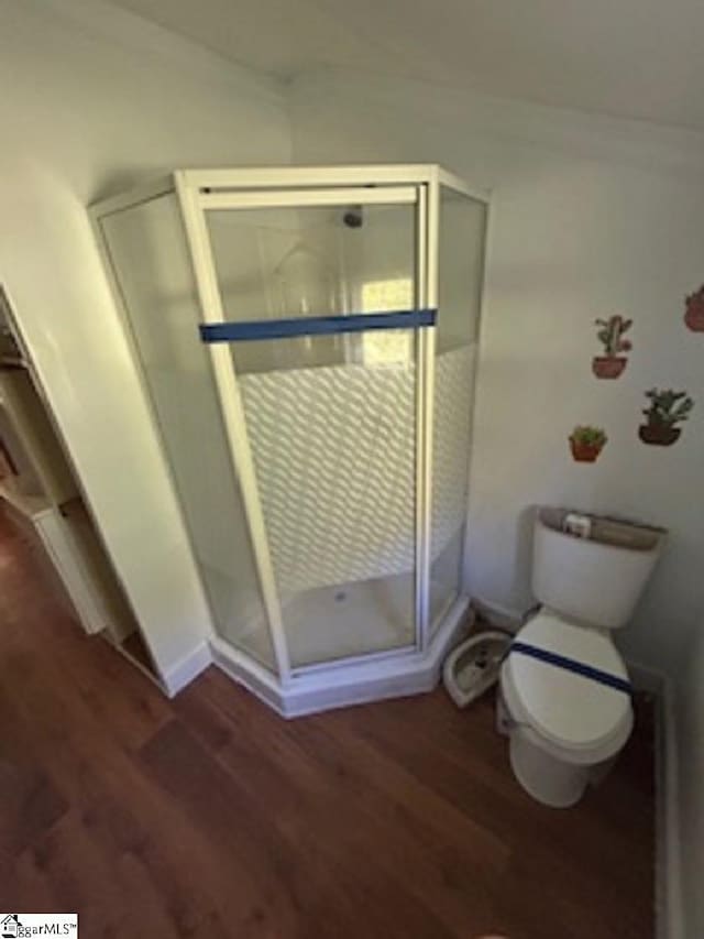 full bathroom featuring crown molding, wood finished floors, a shower stall, and toilet