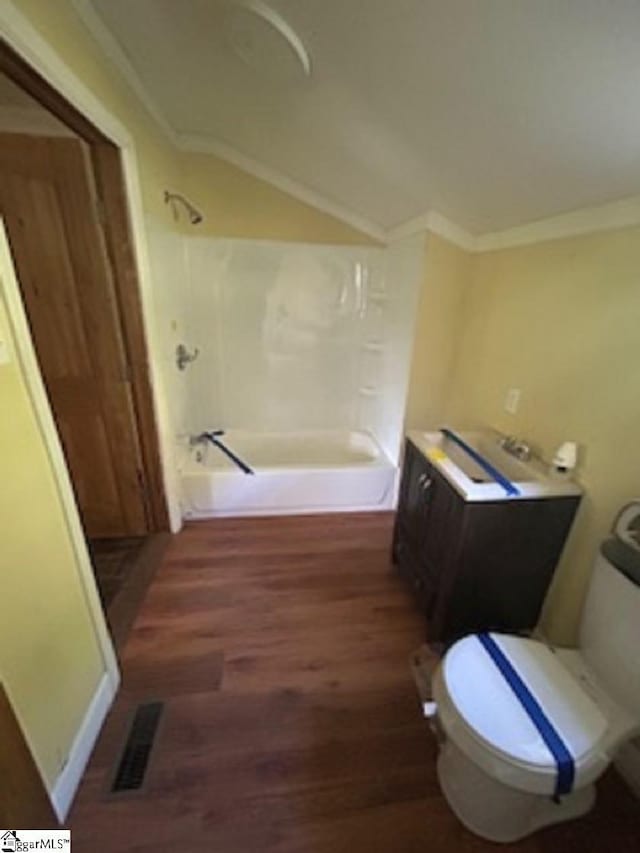 full bathroom featuring bathing tub / shower combination, toilet, vaulted ceiling, visible vents, and wood finished floors