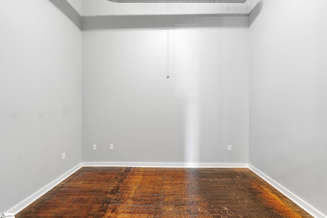 empty room with wood-type flooring and baseboards