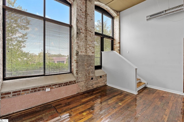 interior space with hardwood / wood-style floors, baseboards, and stairway