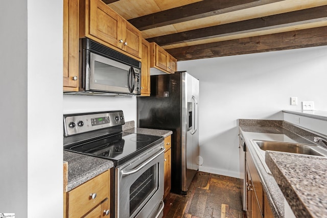 kitchen with dark wood-style floors, beamed ceiling, baseboards, brown cabinetry, and appliances with stainless steel finishes
