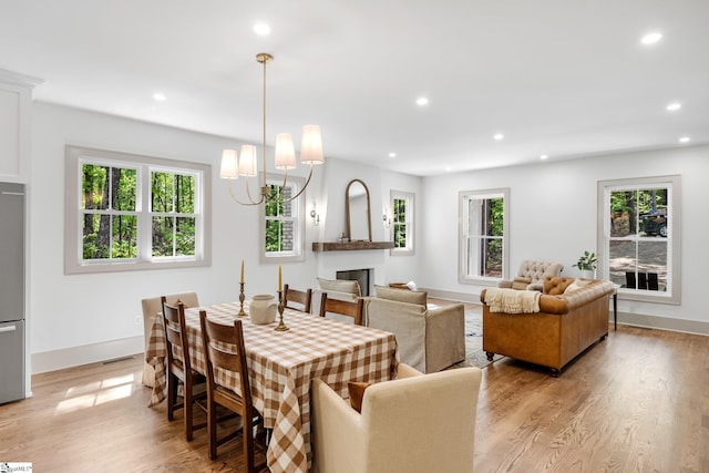 dining space with a fireplace, baseboards, light wood-style floors, and recessed lighting