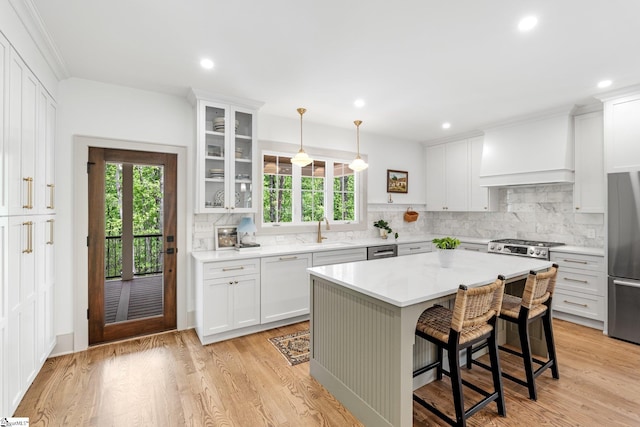 kitchen featuring custom exhaust hood, a sink, appliances with stainless steel finishes, and plenty of natural light