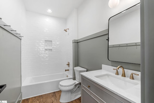 bathroom featuring vanity, wood finished floors, tub / shower combination, and toilet