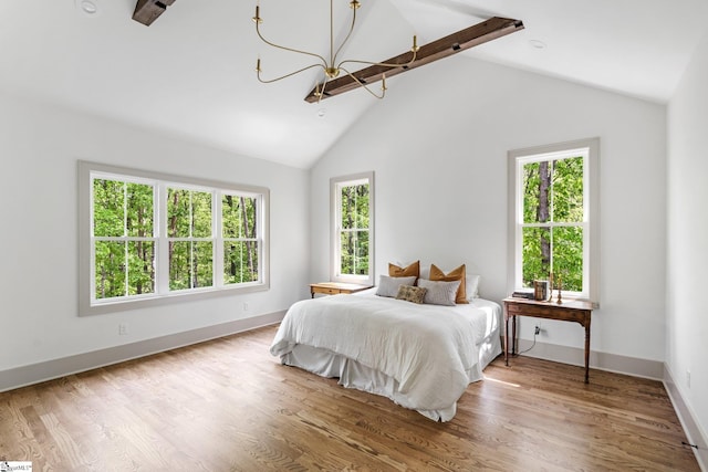 bedroom featuring multiple windows, wood finished floors, vaulted ceiling with beams, and a notable chandelier