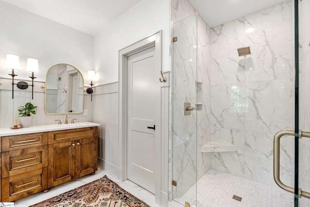 full bathroom with marble finish floor, vanity, and a marble finish shower