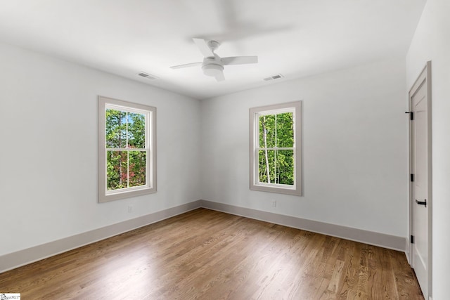 spare room with ceiling fan, light wood-style floors, visible vents, and plenty of natural light