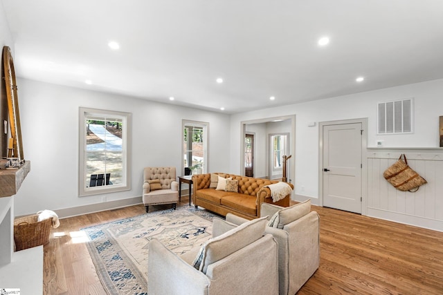 living room with baseboards, wood finished floors, visible vents, and recessed lighting