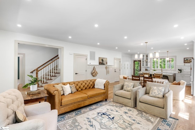 living room featuring visible vents, recessed lighting, and stairs