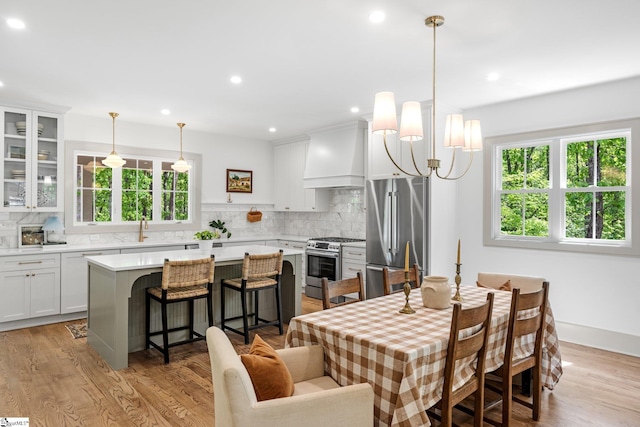 dining area with light wood-style flooring, baseboards, and recessed lighting
