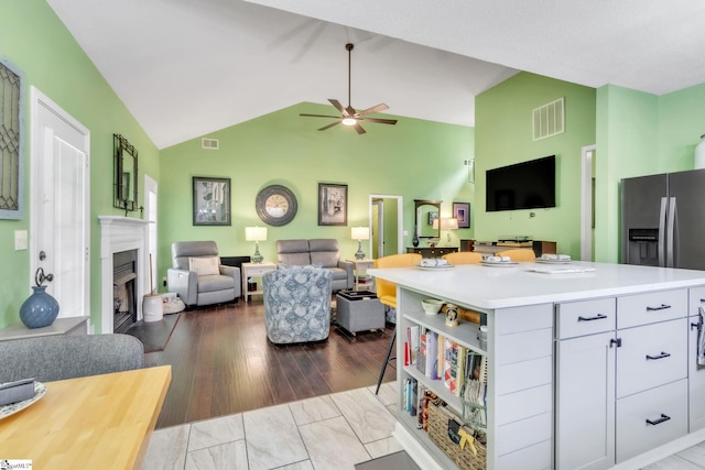 kitchen with light countertops, visible vents, open floor plan, and ceiling fan