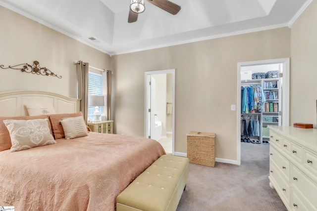 bedroom featuring light carpet, visible vents, ornamental molding, ensuite bath, and a walk in closet