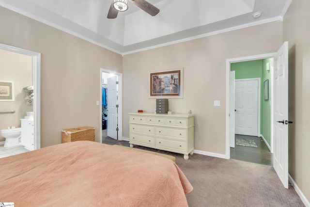 carpeted bedroom with ensuite bathroom, a walk in closet, ceiling fan, baseboards, and ornamental molding