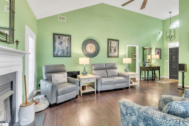 living room featuring wood finished floors, visible vents, a ceiling fan, a fireplace, and high vaulted ceiling