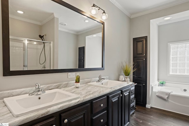 full bathroom with wood finished floors, a sink, double vanity, and a stall shower