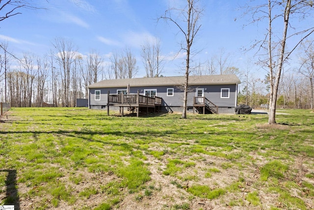 back of house featuring a wooden deck and a yard