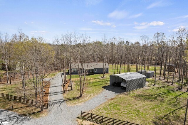 view of home's community featuring a lawn, an outdoor structure, driveway, and fence