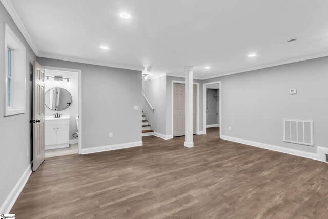 finished below grade area featuring stairway, visible vents, and ornamental molding