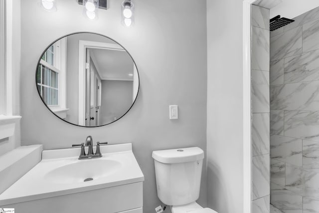 full bath featuring toilet, vanity, and a marble finish shower