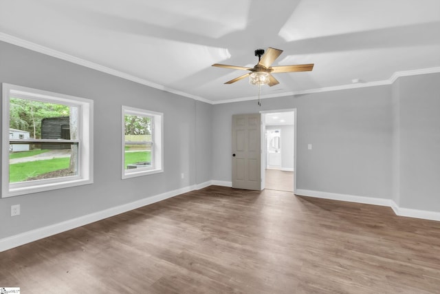 empty room featuring baseboards, a ceiling fan, wood finished floors, and crown molding