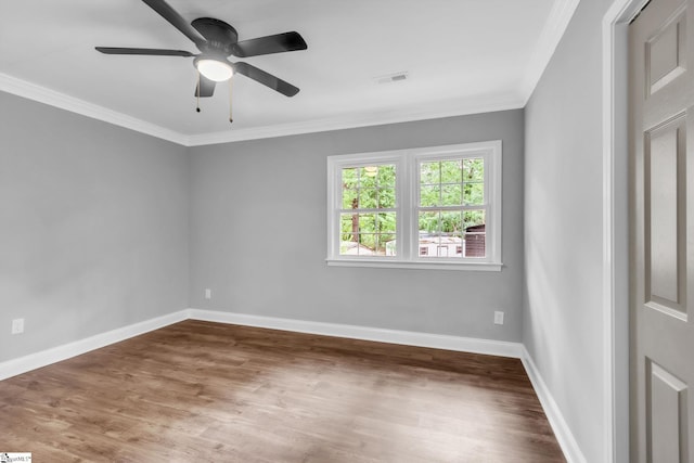 unfurnished room with baseboards, ornamental molding, wood finished floors, and visible vents