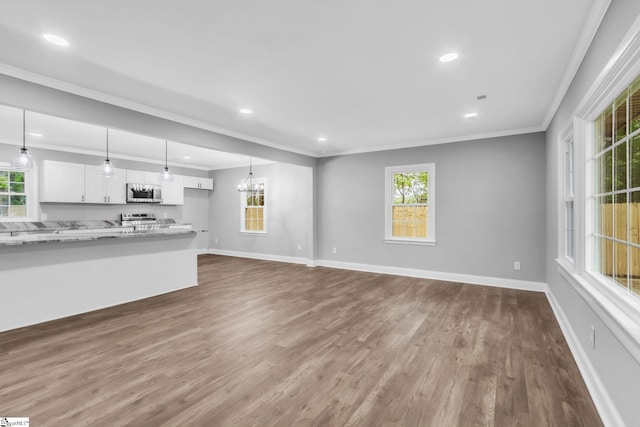 unfurnished living room with dark wood finished floors, baseboards, ornamental molding, and recessed lighting
