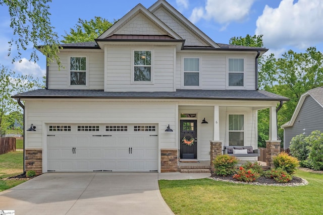 craftsman-style home with a front lawn, driveway, stone siding, a porch, and a garage